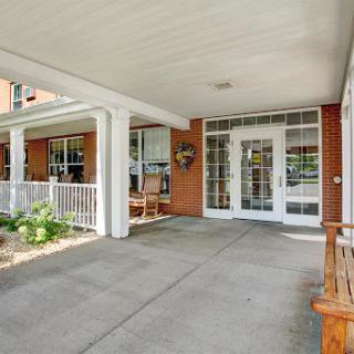 A welcoming entrance to a home with comfortable seating and a spacious porch.