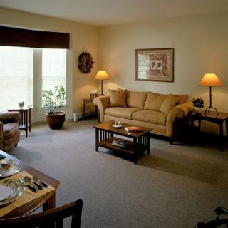 A cozy living room with a sofa, coffee table, and lamps, creating a warm atmosphere.