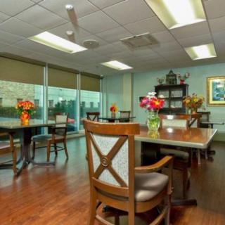 A well-lit conference room with tables, chairs, and decorative flowers.