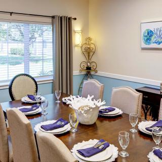 A well-decorated dining room with a neatly set table and elegant furnishings.