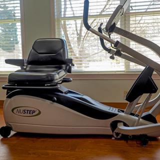 A recumbent exercise bike positioned in a room with natural light from large windows.