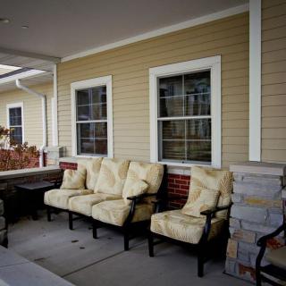 A cozy porch area with cushioned seating and large windows.