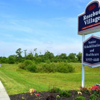 Entrance to Rosebud Village, a senior rehabilitation and healthcare facility surrounded by lush greenery.