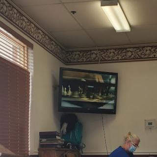 A cozy waiting area featuring a television displaying scenic imagery.