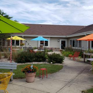 A vibrant outdoor space featuring colorful umbrellas and a beautifully landscaped garden, inviting relaxation.