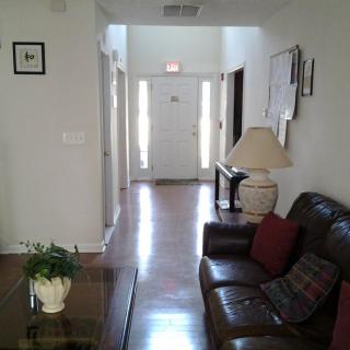 A cozy living room with a view down a hallway towards the front door.