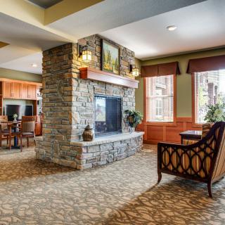 A cozy living room with a stone fireplace and comfortable armchair.