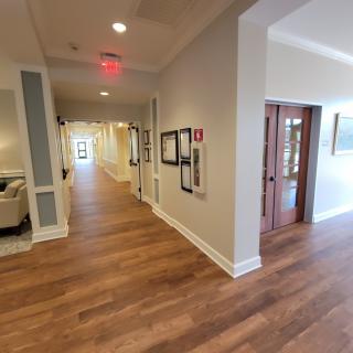 A modern hallway with wooden flooring and artwork adorning the walls.
