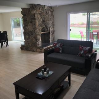 A cozy living room with a stone fireplace and modern furniture.