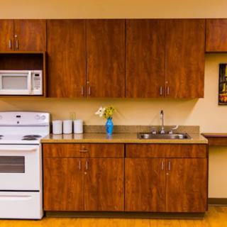 A well-organized kitchen featuring wooden cabinets, a white oven and microwave, and a small countertop with a sink.