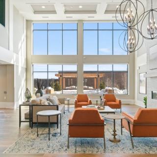 A modern, spacious living room with large windows and stylish furniture.