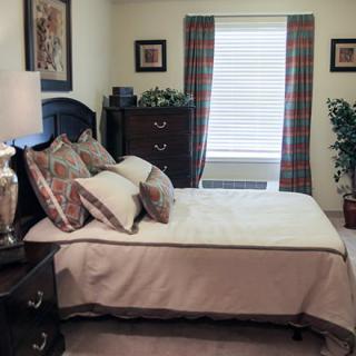 A cozy bedroom with a neatly made bed and stylish decor.