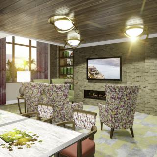 A cozy living room with modern interior design featuring a stone wall, comfortable chairs, and a large TV.