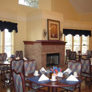 A cozy dining area with a fireplace and elegantly set tables.