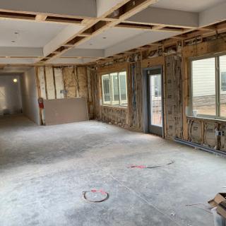 An interior space under renovation, showcasing exposed walls and construction materials.