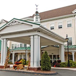 Entrance of a classic-style hotel with columns and landscaping.