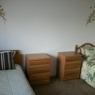 A minimalist bedroom with two single beds separated by nightstands.