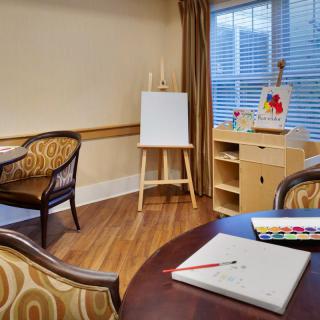 An art room with an easel, drawing supplies, and comfortable seating.