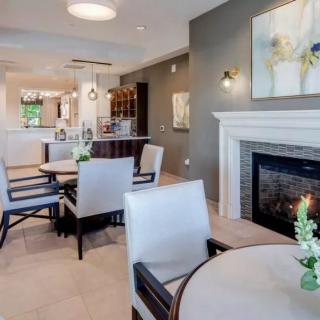 A modern dining area featuring elegant furniture and a cozy fireplace.