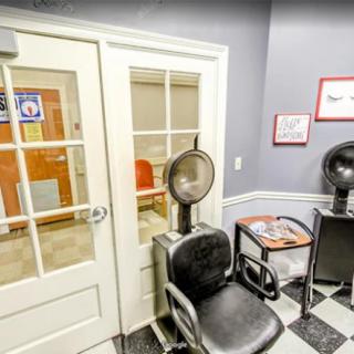 A cozy waiting area in a hair salon with chairs, hair dryers, and magazines.