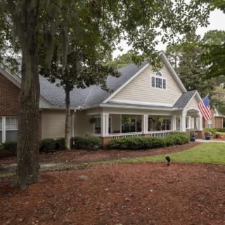 A suburban house with a well-maintained front yard and an American flag displayed.