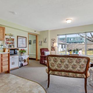 A cozy living room with vintage furniture and a large window overlooking the garden.