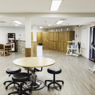A modern interior room with tables, chairs, and storage cabinets.