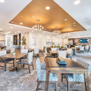 A modern dining area with elegant chandeliers and well-arranged tables and chairs.