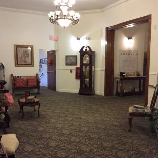 A warmly decorated lobby with antique furniture and a chandelier.