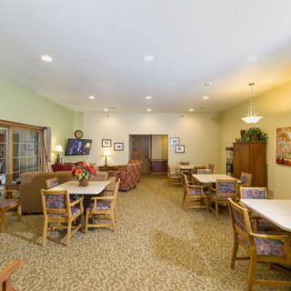 A cozy community dining area with multiple tables and chairs arranged for communal use.
