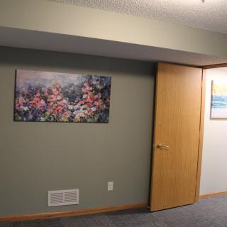 Interior room with paintings on the wall and an open door.