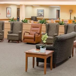 A well-organized waiting room with several comfortable chairs and a table in the center.
