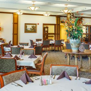 A well-arranged dining area with elegantly set tables and comfortable seating.