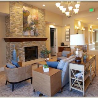 A stylish living room with modern decor featuring a stone fireplace, elegant furniture, and warm lighting.