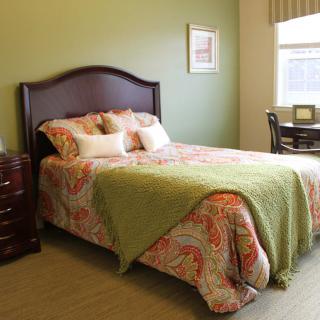 A cozy bedroom with a neatly made bed and stylish decor.