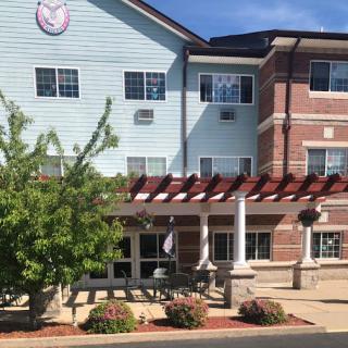 A welcoming hotel exterior featuring a blend of architectural styles and lush greenery.