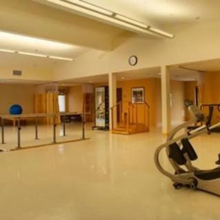 An empty gym with exercise equipment and a spacious workout area.