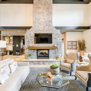 A modern living room featuring a stone fireplace and elegant furniture.