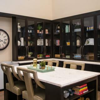 A modern kitchen with dark cabinets and a spacious island surrounded by bar stools.