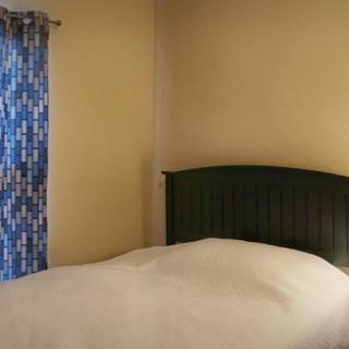 A cozy bedroom with a bed and patterned curtains.