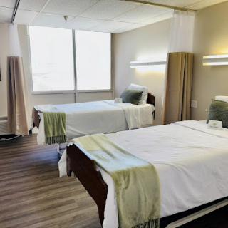 A modern patient room featuring two neatly made beds, designed for comfort and care.
