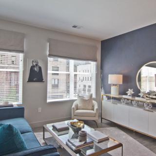 A modern living room with a blue accent wall, featuring a stylish sofa, armchair, and a decorative coffee table.