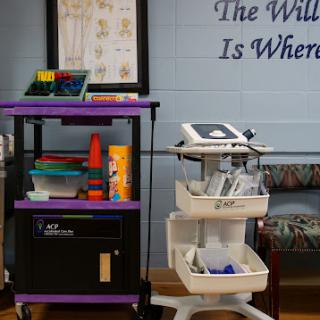 A classroom setup featuring a supply trolley and medical equipment against a motivational wall display.