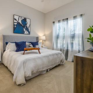 A modern bedroom featuring a comfortable bed, stylish decor, and ample natural light.