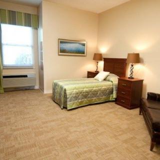A spacious bedroom with a single bed, bedside tables, and lamps.