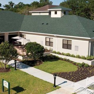 A view of a modern building with landscaped gardens and outdoor seating.