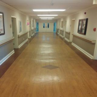 A long corridor with doors on either side, illuminated by overhead lights.