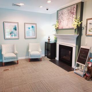 Cozy living room with a fireplace, artwork, and comfortable seating.
