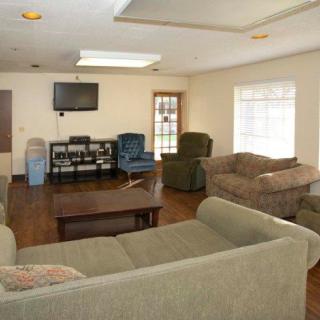 A cozy living room featuring multiple sofas, a coffee table, and a television.