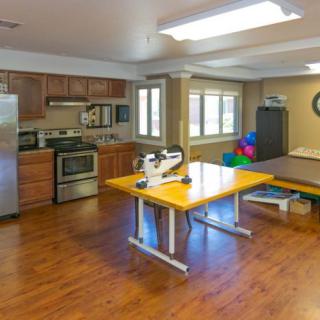 A multi-functional space with a kitchen and therapy equipment.